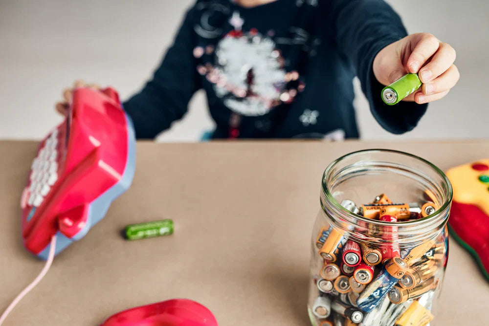 Child putting battery for recycling